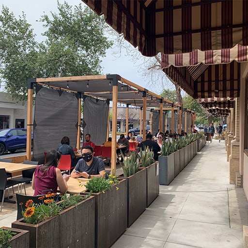 people enjoying pizza n such food in our outdoor parklet area